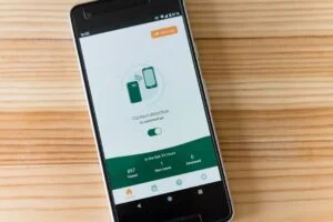 The image-2 product features a smartphone screen with a contact detection app active, displaying testing data including tested, new cases, and deceased numbers. The phone is positioned on a wooden surface.