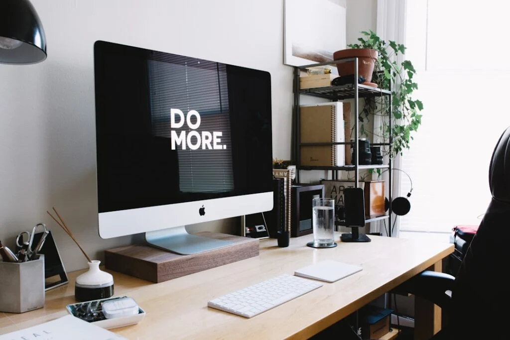 The home office setup in image-6 features a desktop with "DO MORE" displayed, accompanied by a keyboard, mouse, glass of water on the desk, shelves with books and plants to the right, and light streaming through a window.