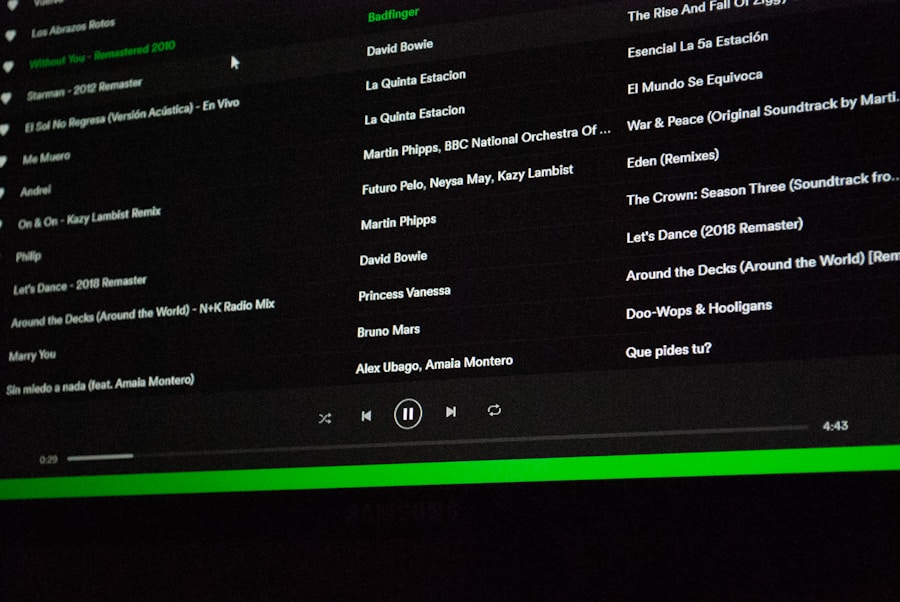 The abcdhe-2 computer screen shows a Spotify music playlist featuring song titles, artists, and albums in Spanish and English with a dark interface, green highlights, and the playback bar at the bottom.