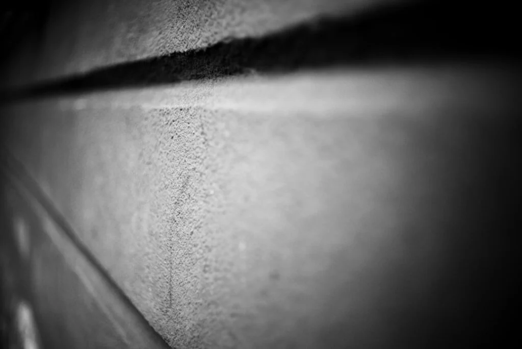 Close-up, black-and-white photo titled "image-2" shows a textured concrete wall with horizontal lines, captured at an angle. The foreground is sharp while the background softly fades out of focus.