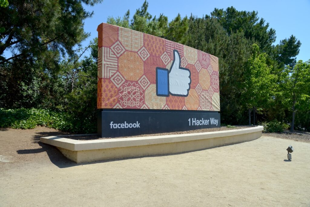 The product image-10 shows a large outdoor sign with a thumbs-up "like" icon at 1 Hacker Way, Facebook headquarters, set against trees and greenery.
