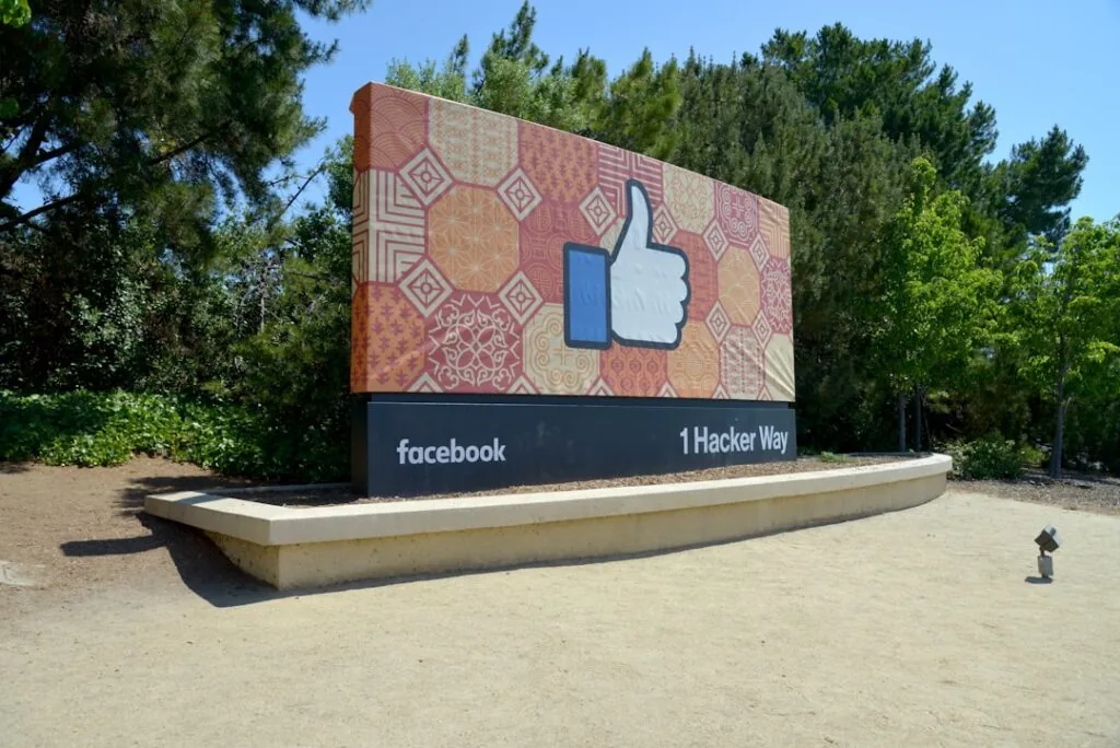 The product image-10 shows a large outdoor sign with a thumbs-up "like" icon at 1 Hacker Way, Facebook headquarters, set against trees and greenery.