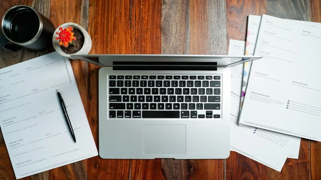 Image-8 shows a laptop on a wooden desk with paperwork, a black pen, coffee cup, and a small potted plant featuring a red cactus.