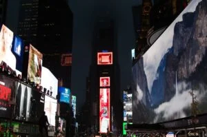 Image-8 shows Times Square at night with bright digital billboards—one displays a scenic mountain landscape—and tall buildings silhouetted against the dark sky.
